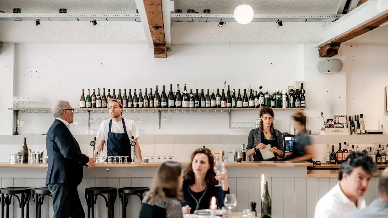 Un bar de restaurant moderne avec des employés derrière le comptoir, respectant les normes d'hygiène et de service.