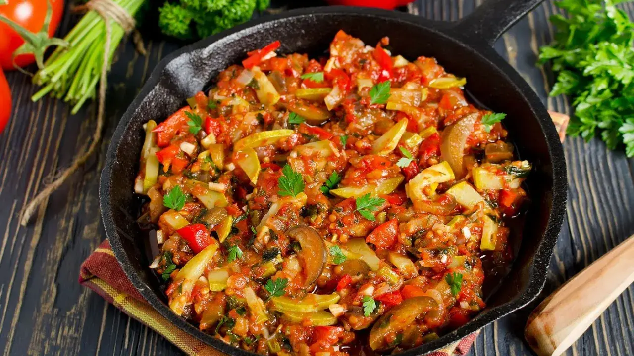 Poêlée de légumes colorée, une spécialité Côte d'Azur, avec courgettes, poivrons et tomates, garnie de persil frais.