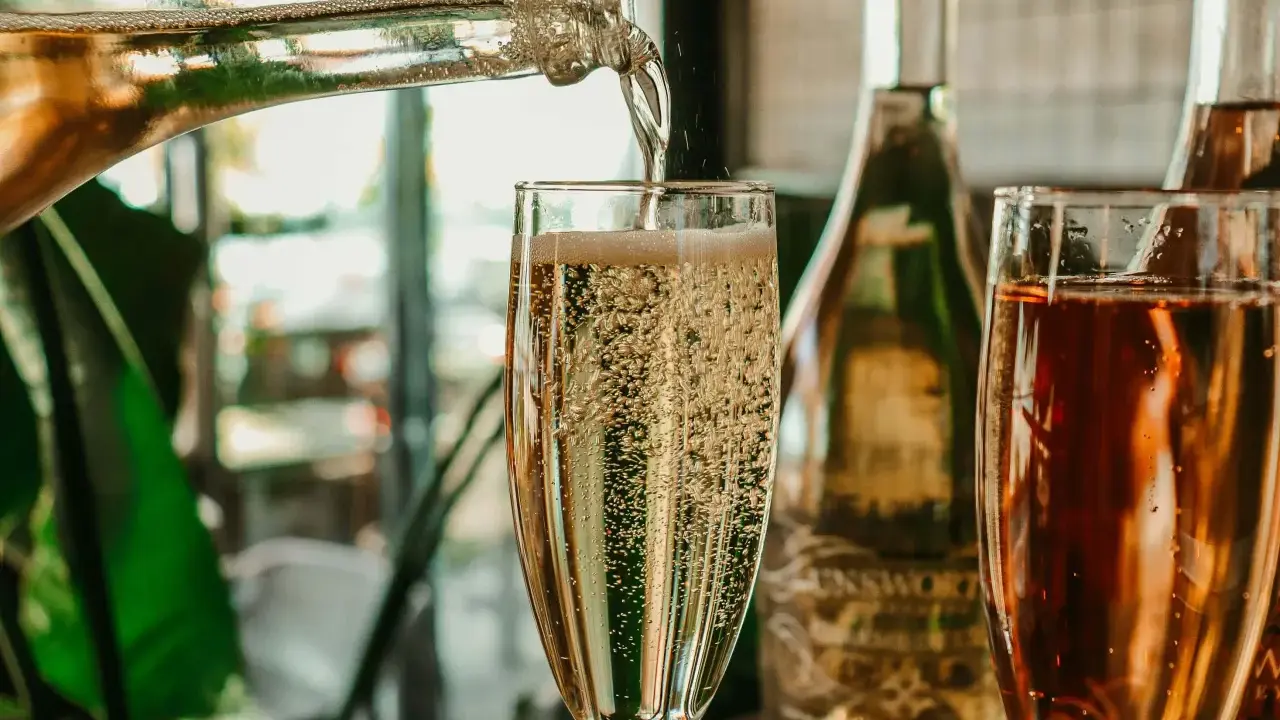 Le champagne pétille dans un verre. On se demande combien de verres dans une bouteille de champagne pour célébrer.