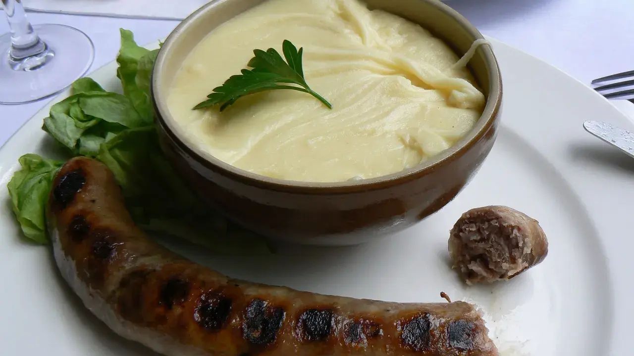 Saucisse grillée et purée onctueuse, un plat traditionnel auvergnat réconfortant.