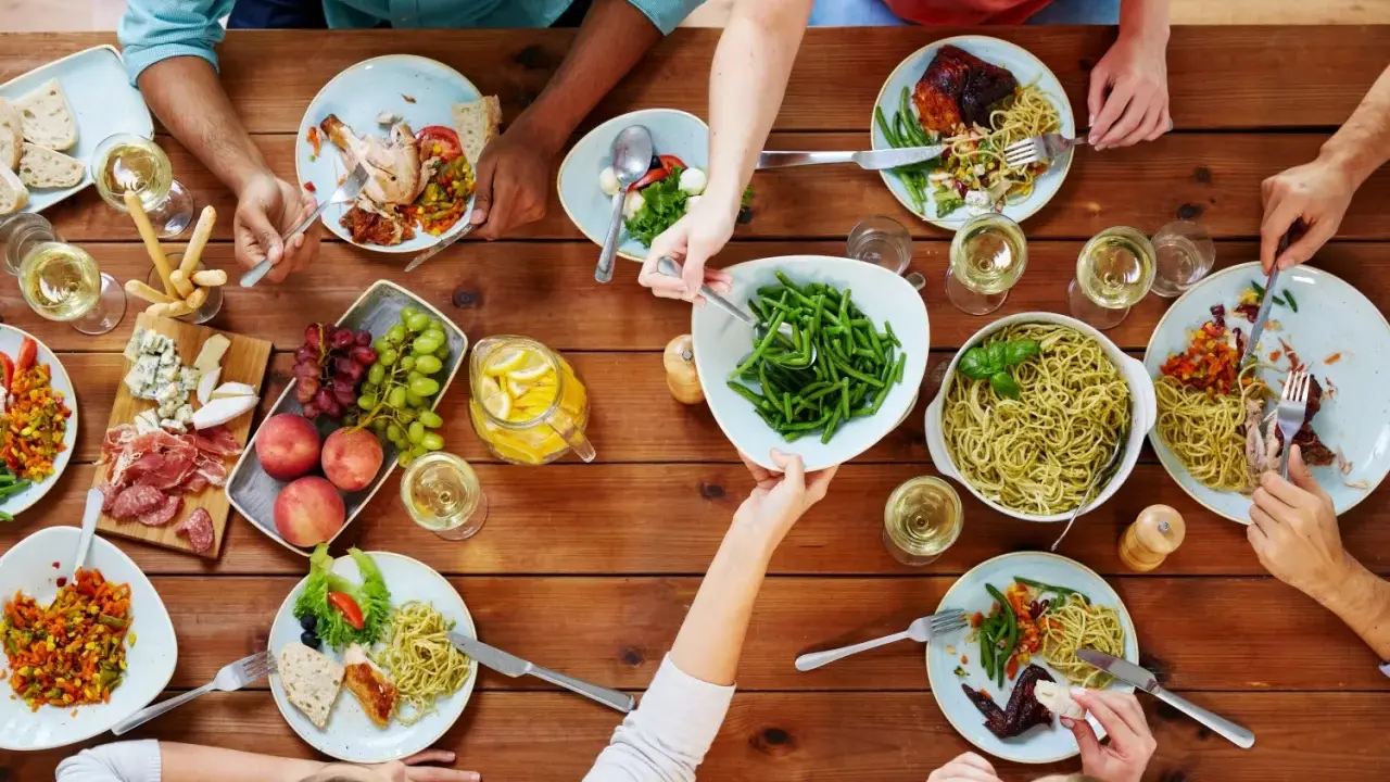 Un repas convivial entre collègues : pâtes, poulet rôti, salade, fruits et charcuterie. Une belle idée repas entre collègues travail.