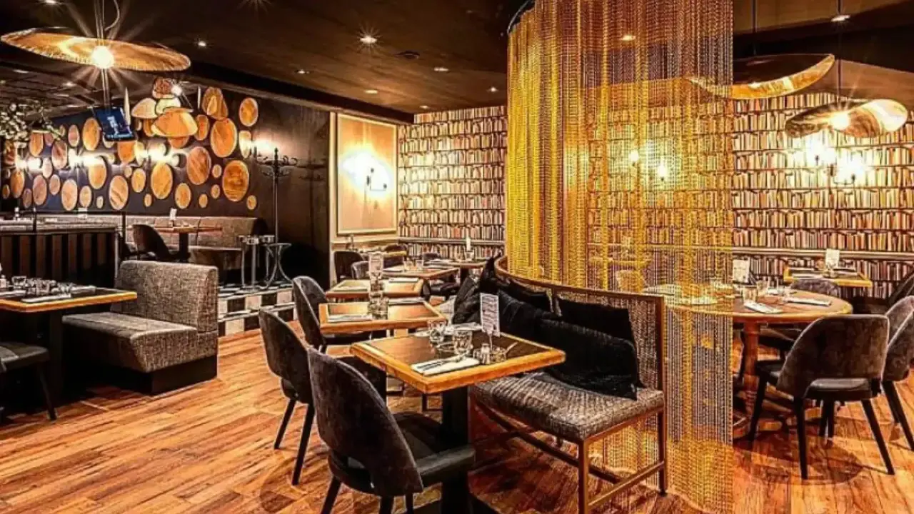 Intérieur chic du restaurant Letz, avec des tables dressées, des banquettes confortables et un rideau de chaînes dorées.