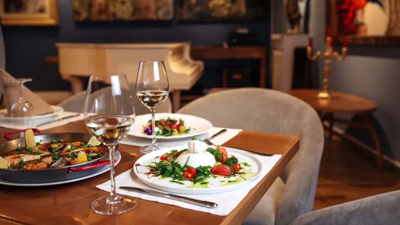 Un dîner romantique dans un restaurant sur Tours. Paella et burrata fraîchement préparées, accompagnées de vin blanc.