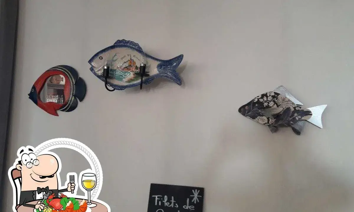Décoration murale en forme de poisson au restaurant Le Saint Pierre La Tronche. Assiette de fruits de mer et verre de vin.