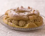 Un Paris-Brest, plat typique d'Île-de-France, garni de crème onctueuse et saupoudré de sucre glace et d'amandes.