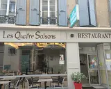 Le restaurant étoilé Les Quatre Saisons à Aurillac, une façade accueillante avec une enseigne lumineuse.