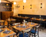 Ambiance chaleureuse dans ces tavernes, avec des tables dressées et des banquettes confortables.