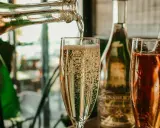 Le champagne pétille dans un verre. On se demande combien de verres dans une bouteille de champagne pour célébrer.