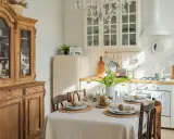 Table dressée pour un repas, avec un buffet ancien et une cuisine lumineuse, évoquant une ambiance de spécialité provençale.