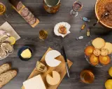 Un festin normand : huîtres, fromages, charcuterie, pommes et douceurs, accompagnés de verres de Calvados, pour savourer les spécialités locales.