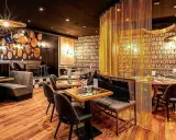 Intérieur chic du restaurant Letz, avec des tables dressées, des banquettes confortables et un rideau de chaînes dorées.