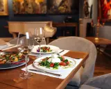 Un dîner romantique dans un restaurant sur Tours. Paella et burrata fraîchement préparées, accompagnées de vin blanc.
