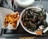 Moules-frites, un plat typique de Saint-Malo, servi avec des frites croustillantes.