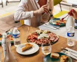 Un plateau de charcuterie et fromages, une spécialité provençale, partagé autour d'une table ensoleillée.
