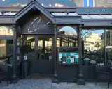 La façade de la meilleure brasserie Saint-Malo, "Le Cancaluen", avec son enseigne élégante et ses grandes vitrines reflétant la ville.