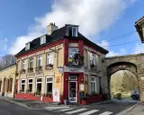 Façade de la Taverne Vauban à Bergues, avec une enseigne et une décoration de cycliste.
