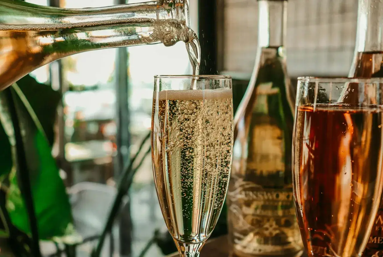 Le champagne pétille dans un verre. On se demande combien de verres dans une bouteille de champagne pour célébrer.