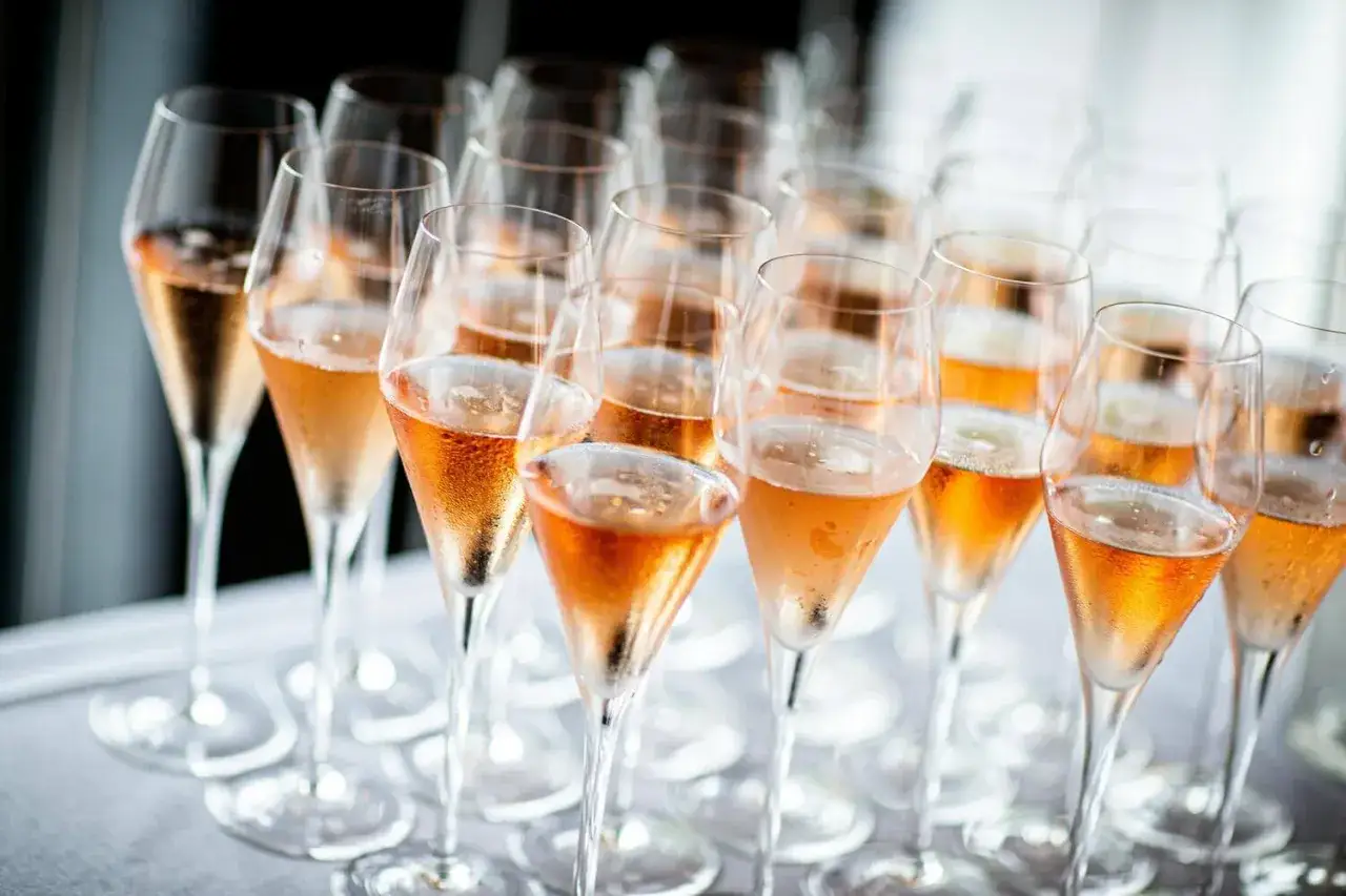 Des verres de champagne rosés, prêts à être servis. Une invitation à célébrer, une promesse de joie. Comment servir le champagne ? Avec élégance et fraîcheur.