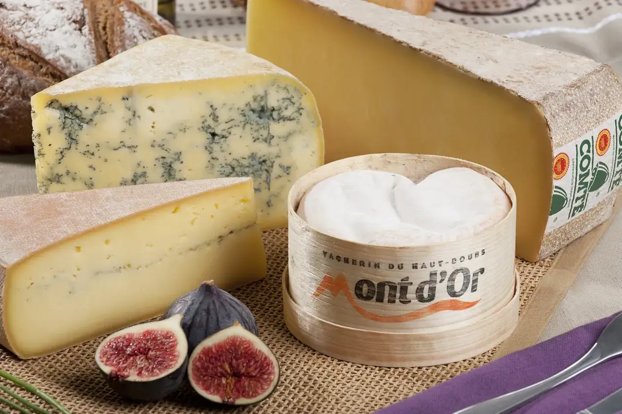 Un Mont d'Or crémeux, un Comté affiné et un fromage bleu, spécialité Jura, accompagnés de figues fraîches.