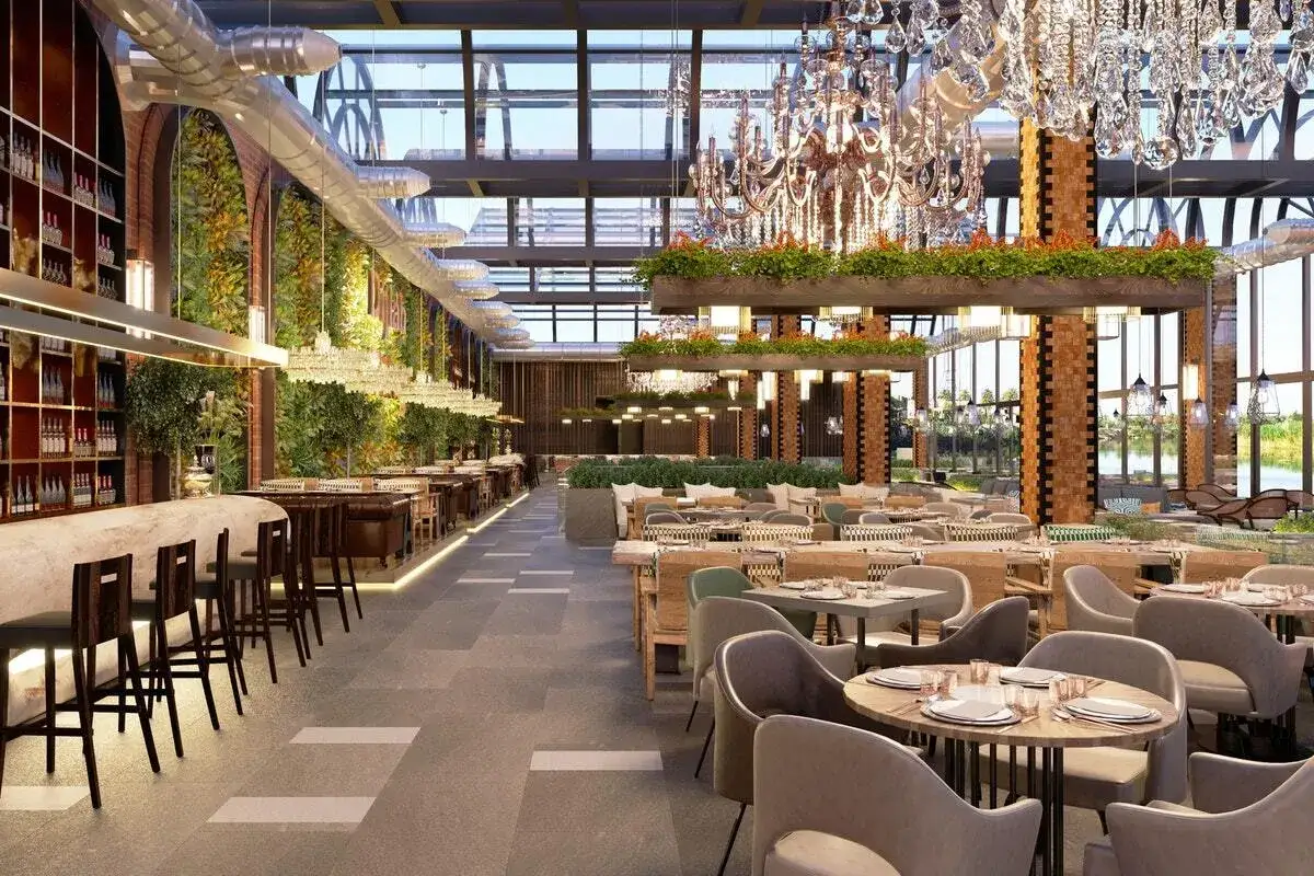 Un restaurant spacieux avec un bar, des tables dressées et des lustres imposants. L'art de la table professionnel est mis en valeur par le design élégant et les plantes luxuriantes.