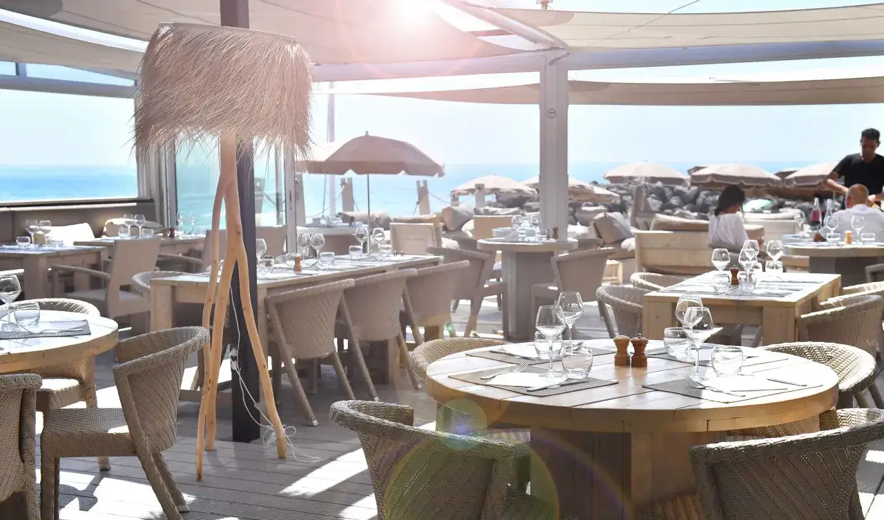 Terrasse ensoleillée du restaurant Le Saint Pierre La Tronche, tables dressées avec vue sur la mer.