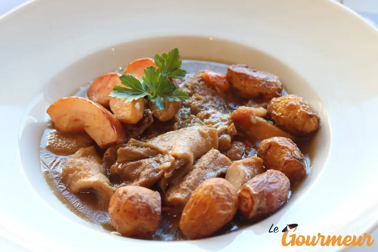 Un plat savoureux de tripes à la mode de Caen, garni de pommes de terre rôties et de persil frais.
