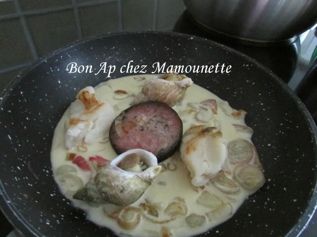 Poêlée de fruits de mer et sa rondelle de boudin noir, une spécialité normande salée crémeuse.