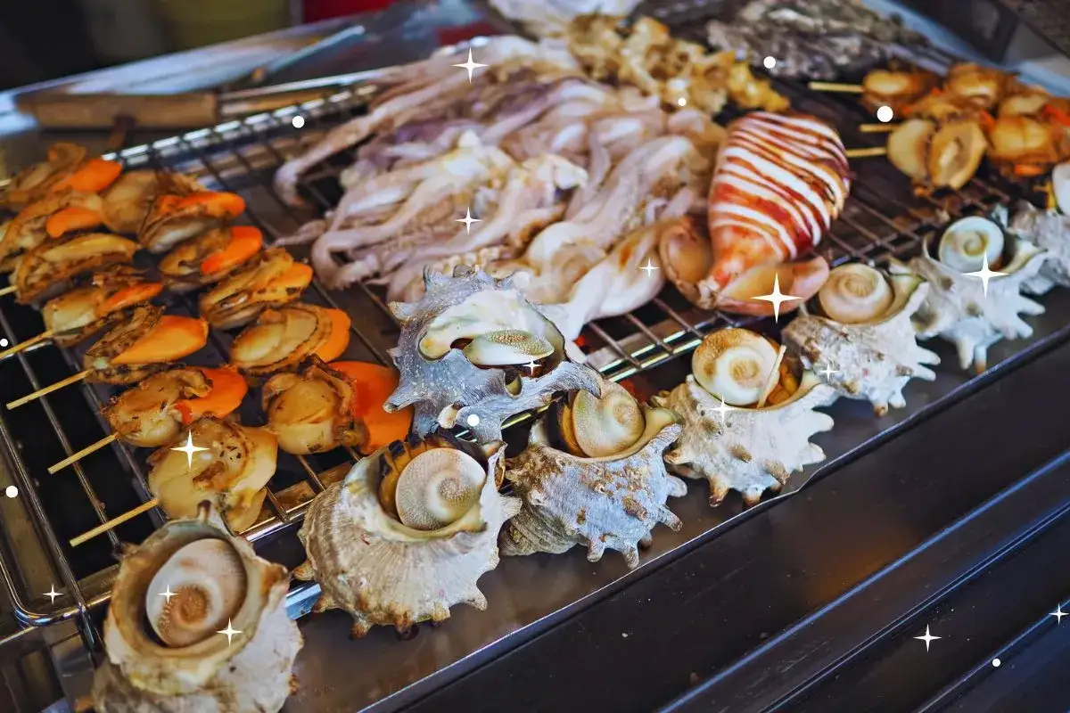 Délicieux o de mer saint malo grillés : Saint-Jacques, calamars et escargots de mer dans leurs coquilles. Un festin savoureux !