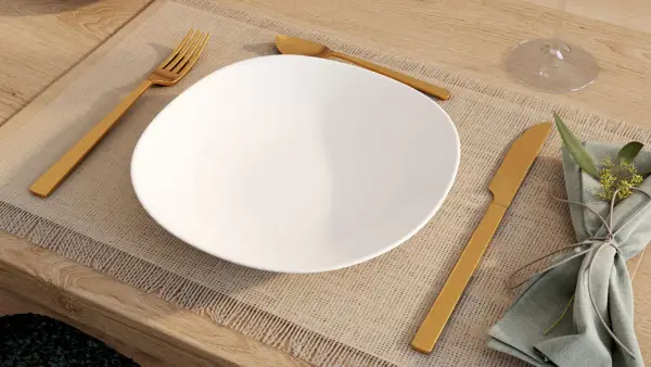 Une assiette blanche est dressée sur un set de table, avec la position des couverts à la française : fourchette à gauche, couteau à droite.