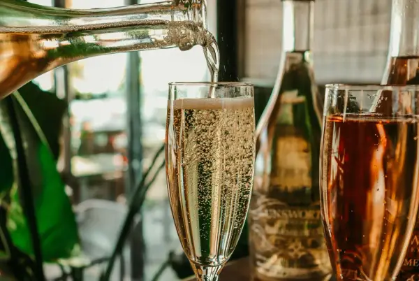 Le champagne pétille dans un verre. On se demande combien de verres dans une bouteille de champagne pour célébrer.