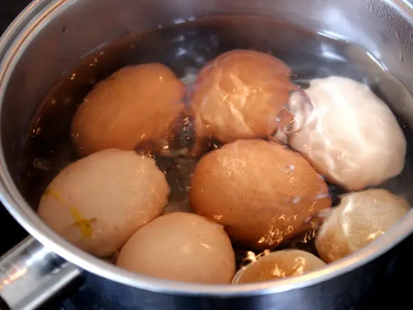 Des œufs dans une casserole d'eau bouillante, prêts pour la cuisson des œufs durs.