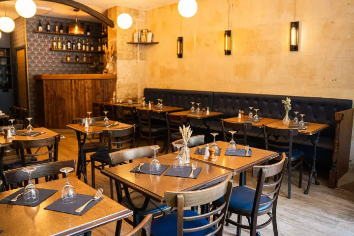 Ambiance chaleureuse dans ces tavernes, avec des tables dressées et des banquettes confortables.