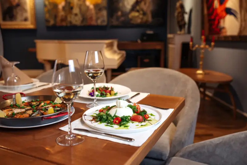 Un dîner romantique dans un restaurant sur Tours. Paella et burrata fraîchement préparées, accompagnées de vin blanc.